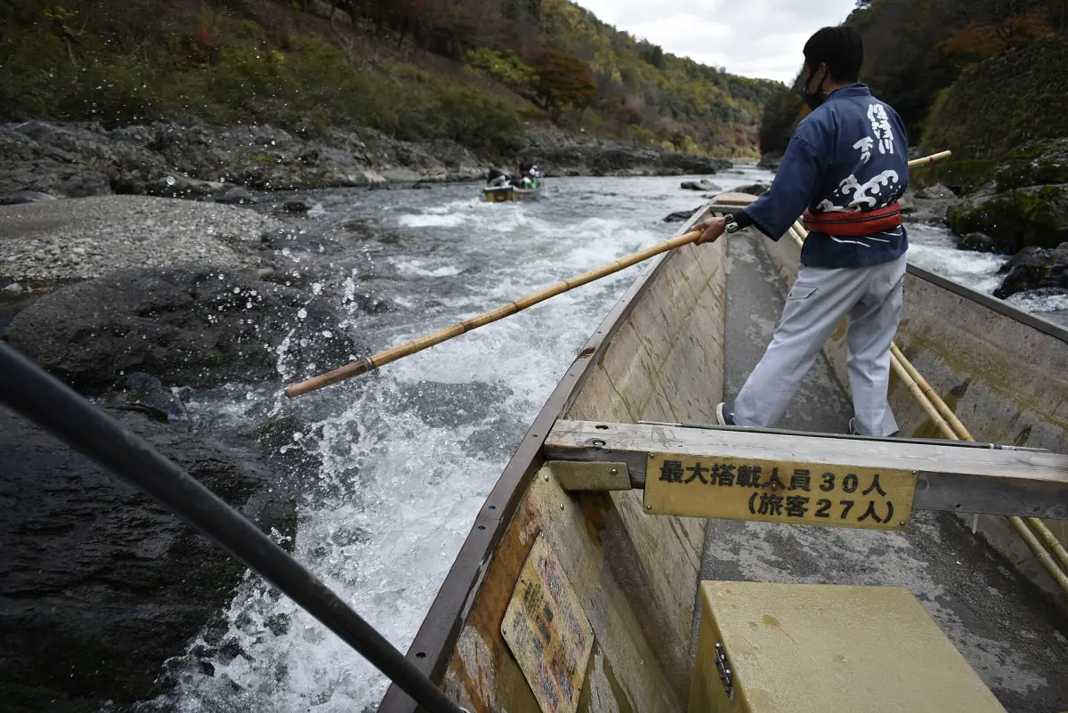 A boatman with a pole on the Hozu river boat