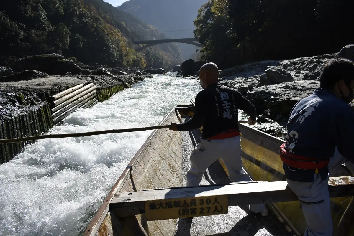 A boatman steering through rapids on the Hozu